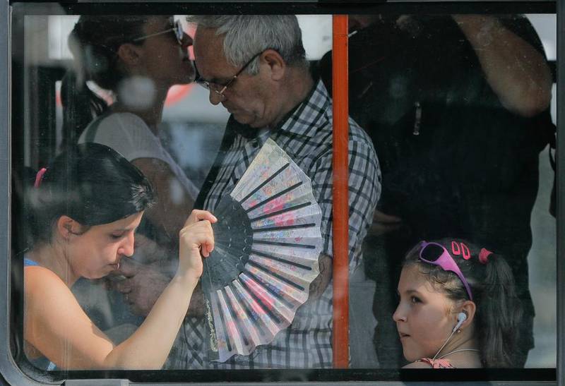 Bildet viser en kvinne med vifte på en buss i Bucuresti i Romania. 