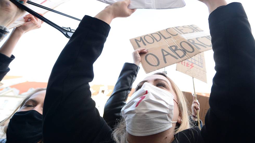 Bildet viser protesterende kvinner med munnbind og plakater.