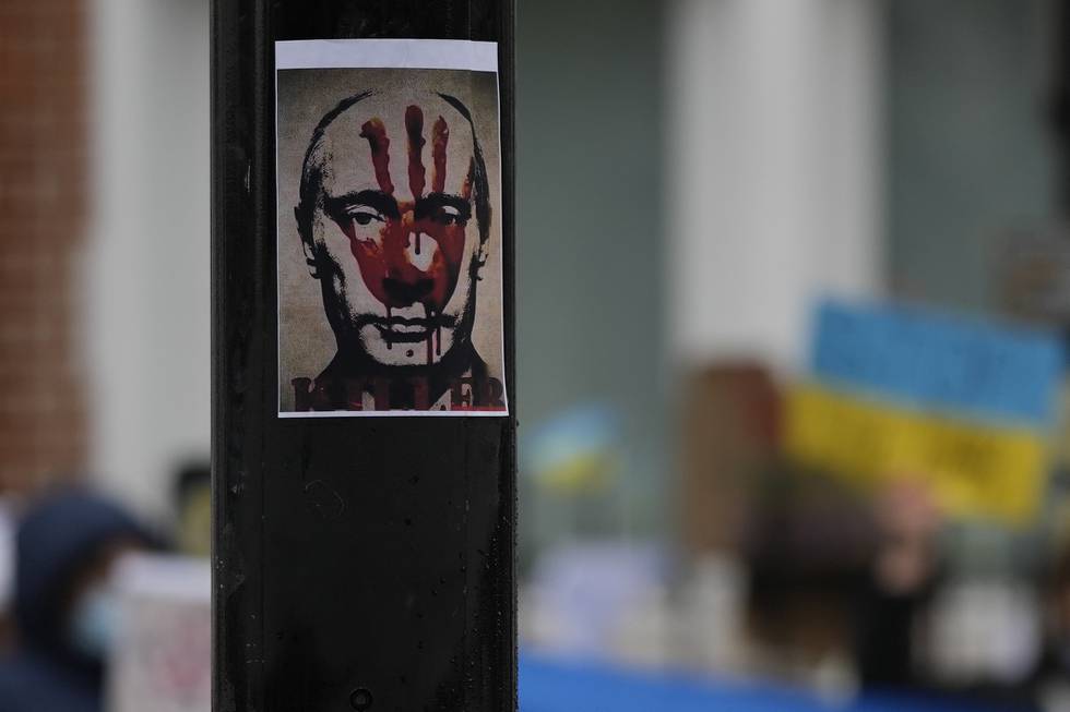 Bildet viser en plakat med bilde av Russlands president Vladimir Putin i London. Ansiktet hans er malt med et rødt håndavtrykk.