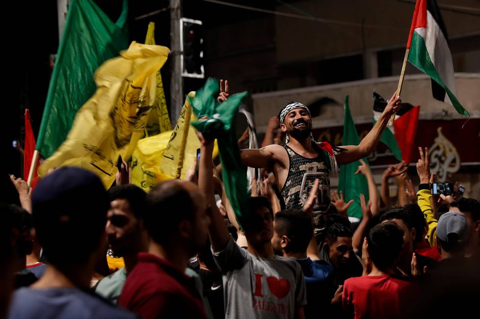 Bildet viser palestinere på Gazastripen som feirer med flagg.