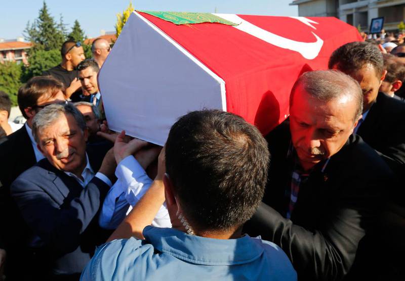 Bildet viser president Recep Tayyip Erdogan som er med og bærer en kiste i en begravelse.
