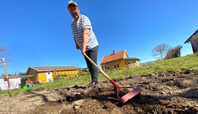 Bildet viser Øyvind Woie som står med redskaper i potetåkeren sin.