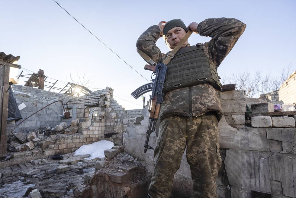 En ukrainsk soldat justerer geværet sitt i Donetsk-regionen ved et hus som ligger i ruiner som følge av krigen. Foto: Andrij Dubtsjak / AP / NTB