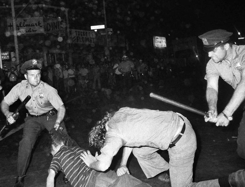 Bildet viser politi som slår folk med klubber.