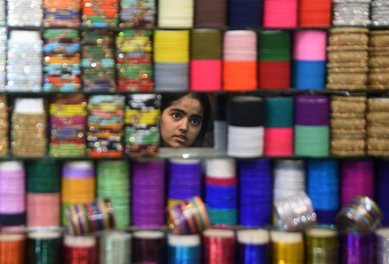 Bildet viser en pakistansk jente som leter etter fargerike armbånd.  