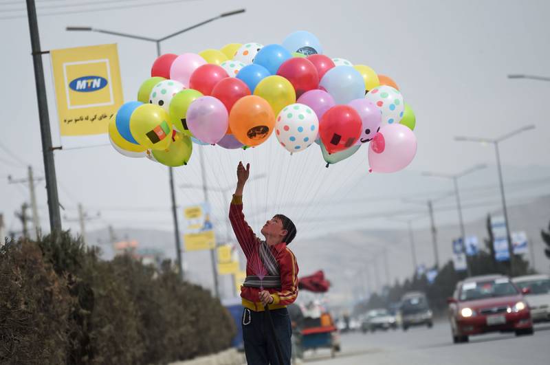 Bildet viser en gutt som selger ballonger.