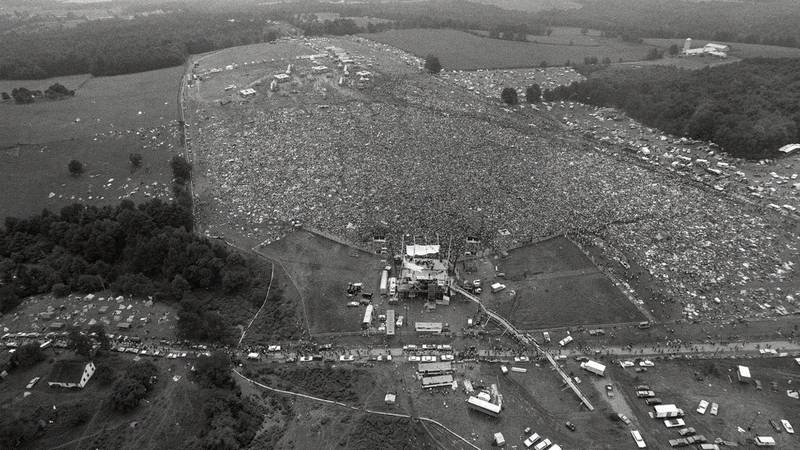 Bildet viser Woodstock-festivalen fra lufta. Det er mange mennesker og telt på bildet.