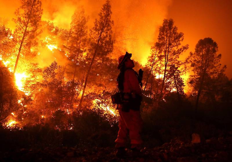 Bildet viser en brannmann i flammehav.