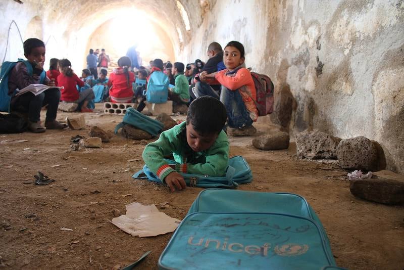 Bildet viser barn som går på skole i Syria. De har en hule under jorda som klasserom.