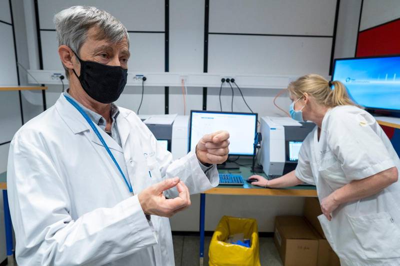 Bildet er av laboratorieleder Fredrik Müller og en medarbeider på korona-laboratoriet på Ullevål sykehus. De har på munnbind. I bakgrunnen er det avanserte maskiner for å undersøke prøver.
