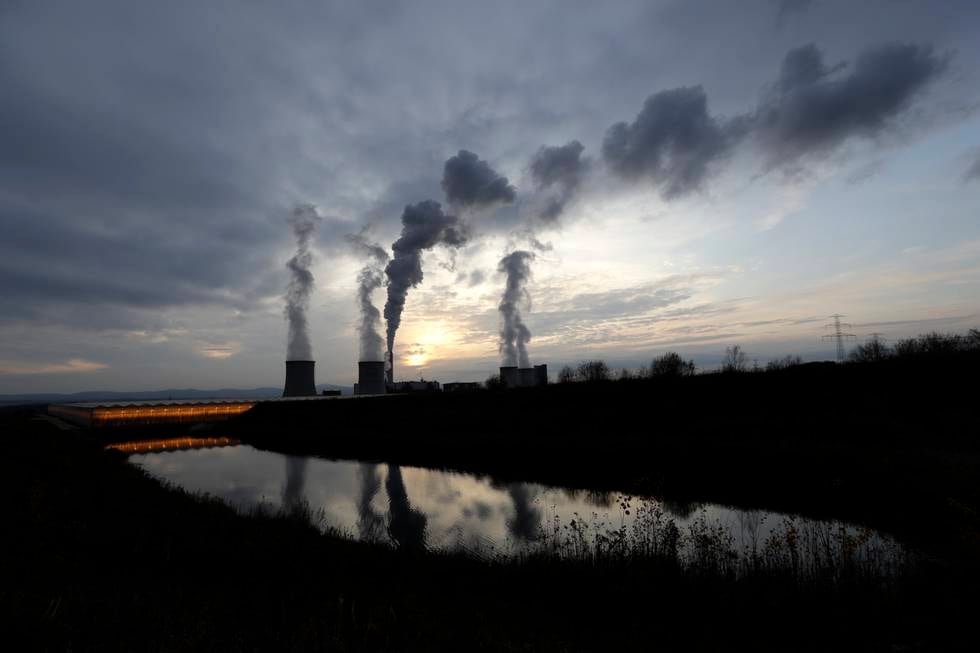 Bildet er av kullkraftverket Turow i Polen. Det er få skyer på himmelen, mens det kommer tykk, mørk røyk opp fra pipene på kraftverket. Foto: Petr David Josek / AP / NTB