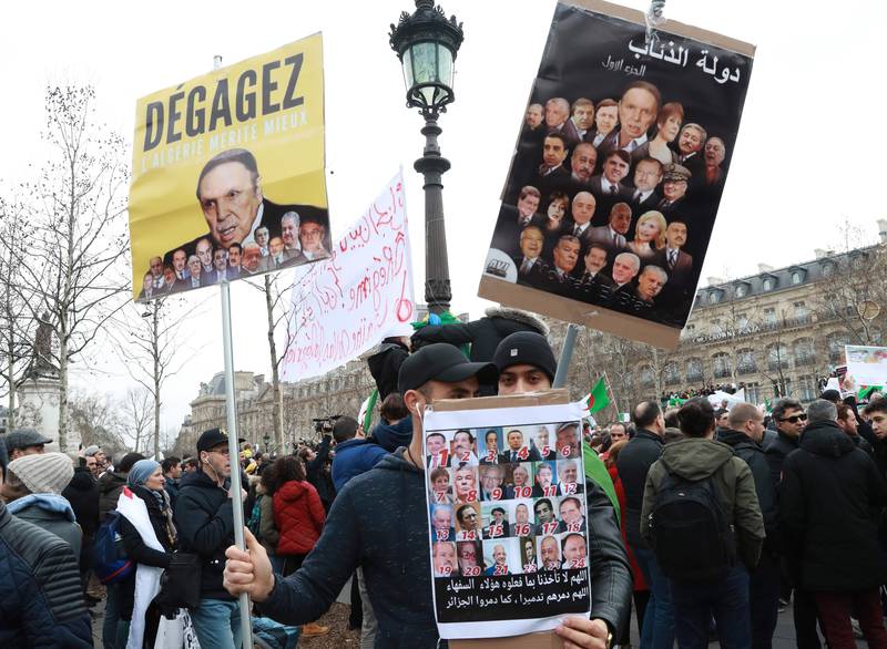Bildet viser demonstranter i Frankrike med plakater mot presidenten i Algerie.