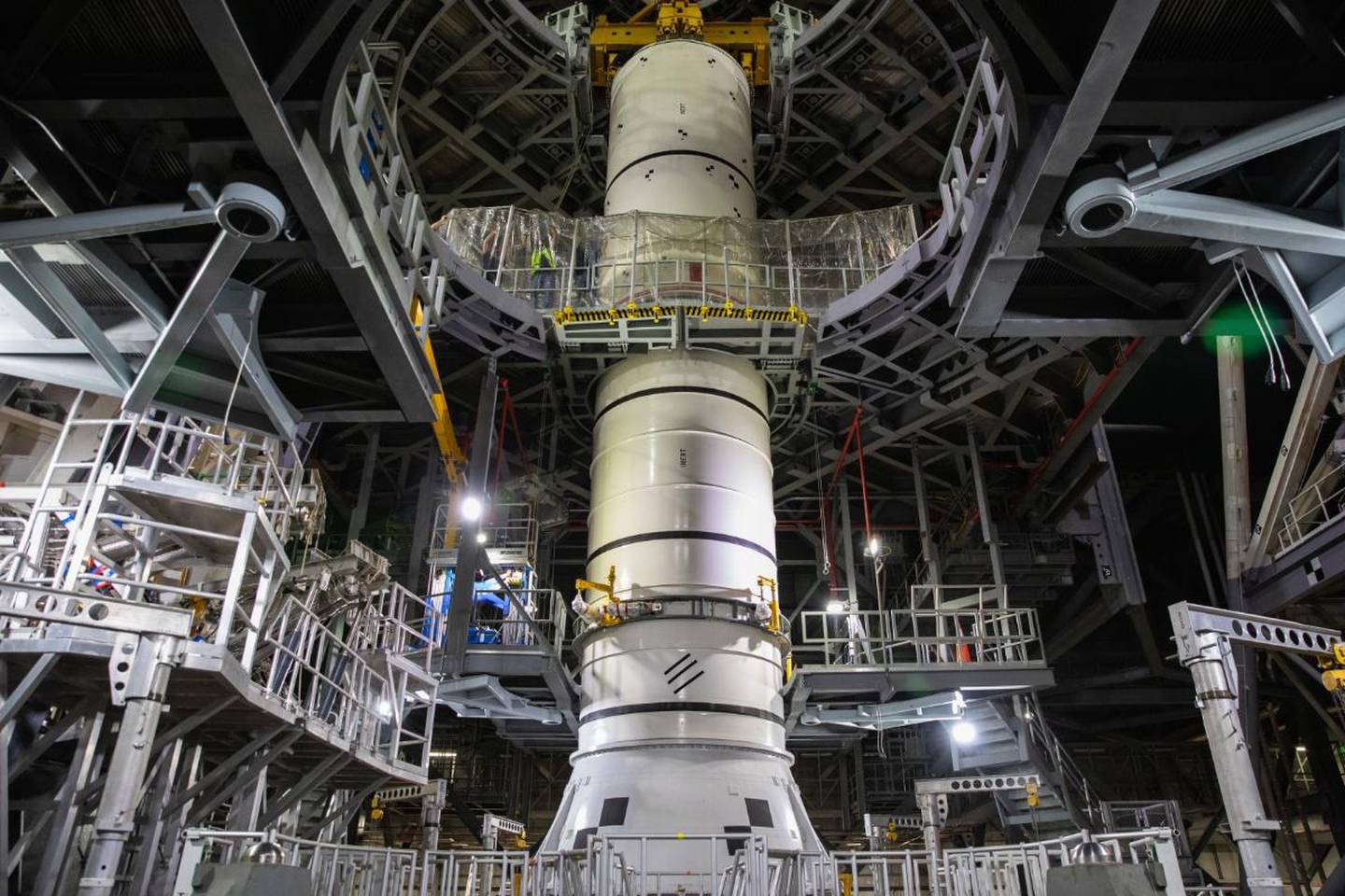 Bildet er av folk i en stor byggehall. I midten er en kjempestor modell av raketten Artemis 1.