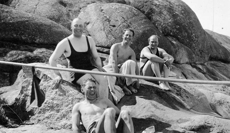 Bildet er av en gruppe menn som sitter på et svaberg. En av dem er det som skulle bli Norges konge, Olav 5.