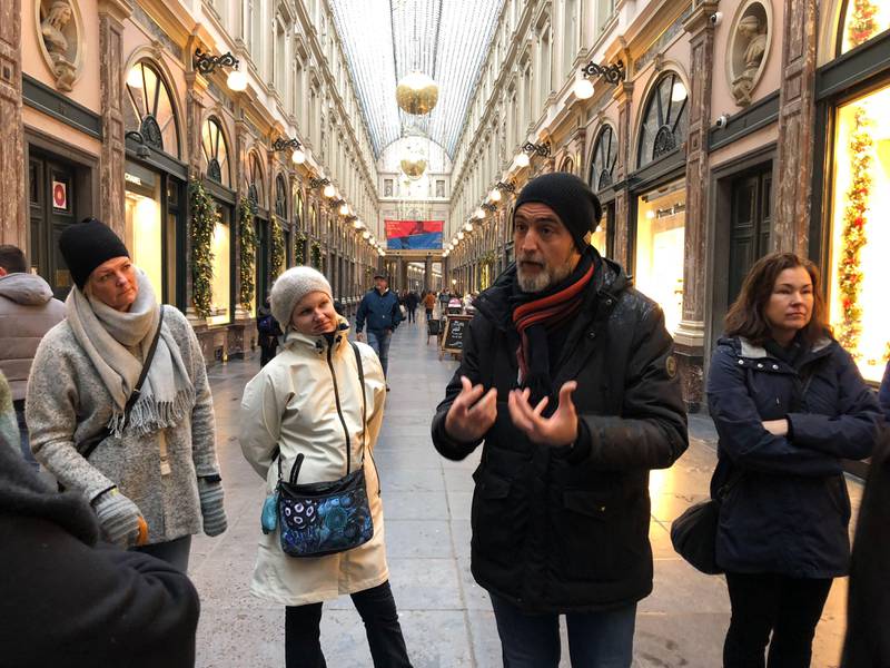 Bildet viser folk som står pi en handlegate i Brussel og lytter til en mann som snakker. De er turister på sjokoladetur.
