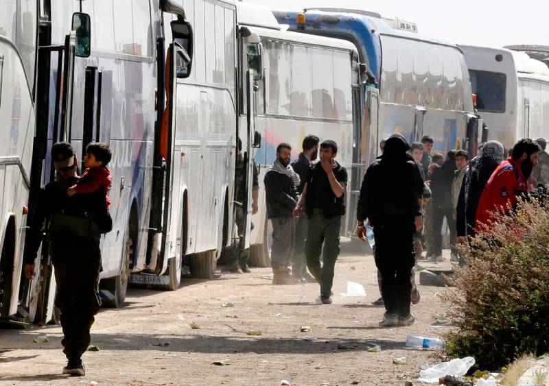 Bildet viser folk og busser i Øst-Ghouta i Syria.