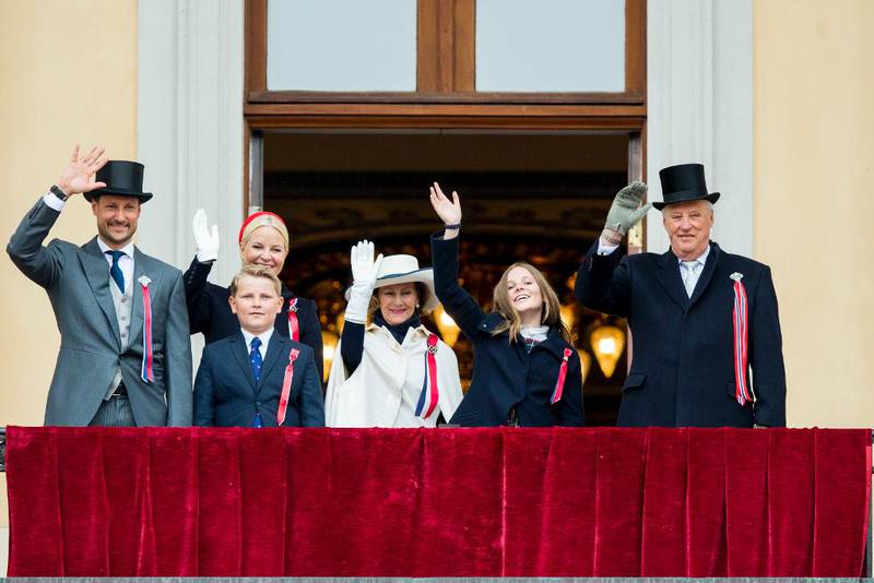 Bildet viser Kronprinsen, kronprinsessen, prins Sverre Magnus, Dronning Sonja, prinsesse Ingrid Alexandra og Kong Harald. De vinker fra balkongen på Slottet.