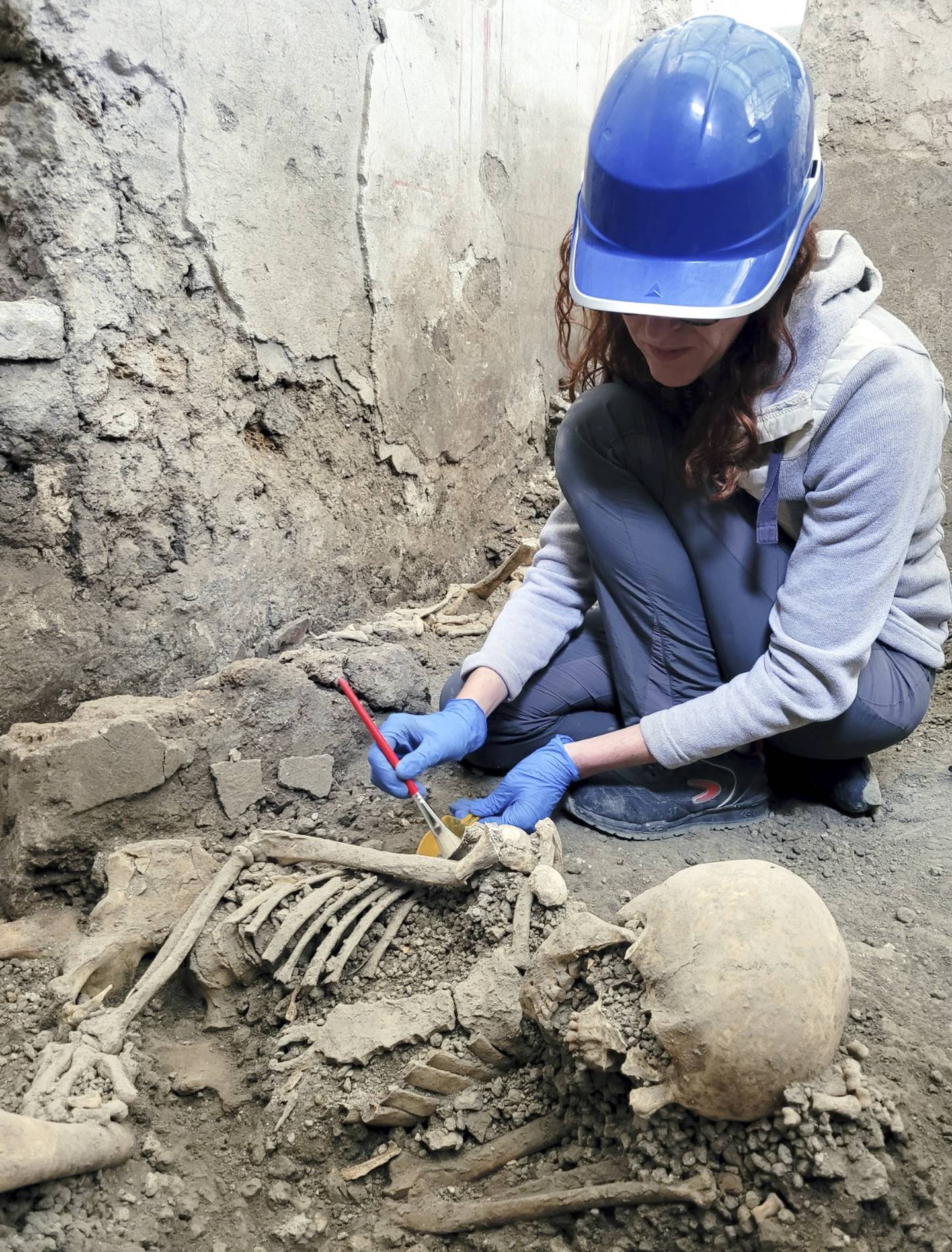 En arkeolog viser fram et av skjelettene som er funnet nylig i Pompeii. Foto: Pompeiis arkeologiske park via AP / NTB