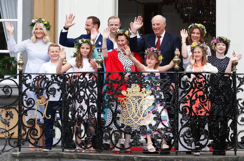 Bildet viser hele kongefamilien som vinker og smiler. De feirer kongeparets 25 år på tronen. 