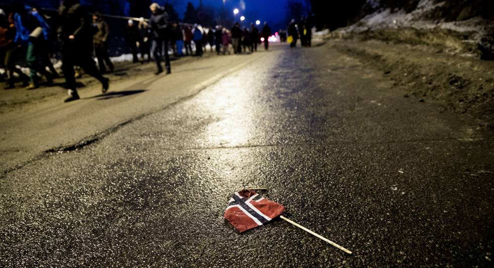 Bildet viser folk som er på vei hjem lørdag. Et norsk flagg ligger på bakken.