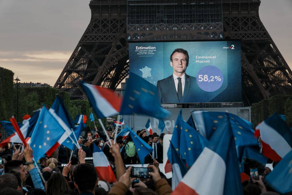 Emmanuel Macron kan se fram til fem nye år som Frankrikes president. Støttespillerne hans har samlet seg foran Eiffeltårnet og jublet da de foreløpige valgresultatene ble klare. Foto: Thibault Camus / AP / NTB