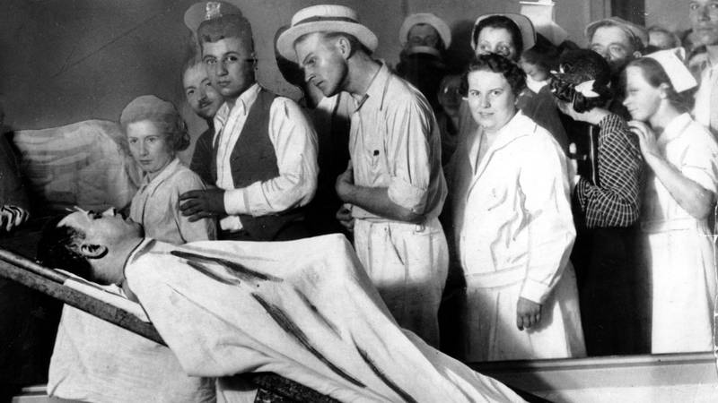 Bildet viser folk som står og ser på liket av John Dillinger.