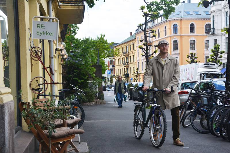 Bildet viser en Kirill Yakolov med sykkelen sin foran verkstedet.