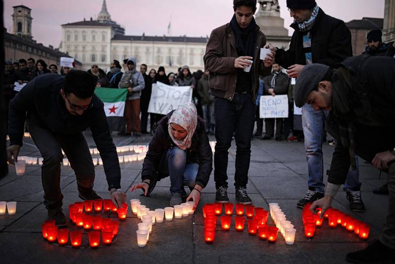 Bildet viser folk som tenner lys for Syria i Italia. Syria er skrevet med lysene.