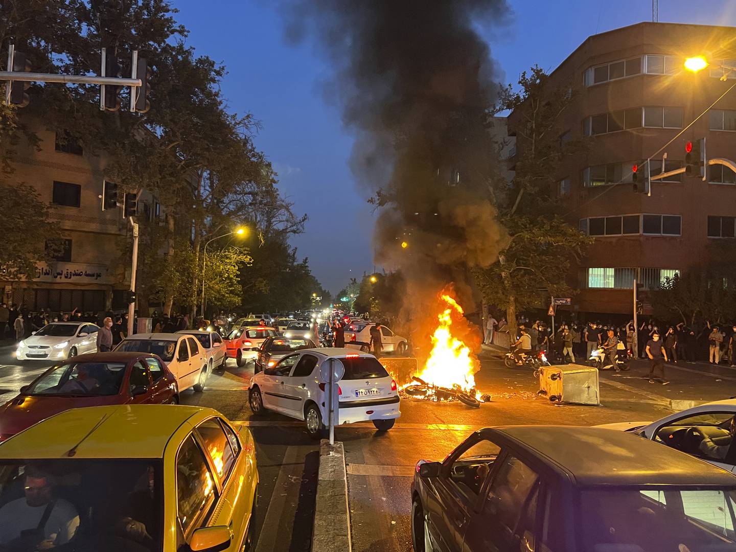 Ein motorsykkel står i brann i samband med ein protest mot at ei ung kvinne døydde i varetekt etter å ha vorte arrestert av moralpolitiet i Teheran. Foto: AP / NTB