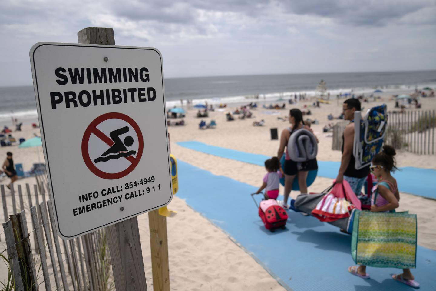 Når haier observeres i nærheten, dukker det midlertidige forbud mot bading. Her har forbudt-skiltet dukket opp på stranda Smith Point County Park på Long Island, der en hai angrep en badevakt 15. juli. Foto: John Minchillo / AP / NTB