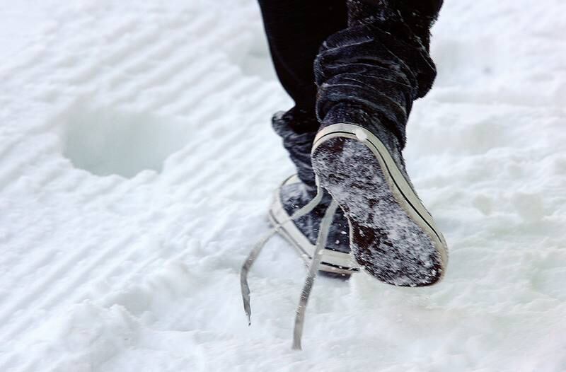 Bildet viser et par joggesko i snøen.