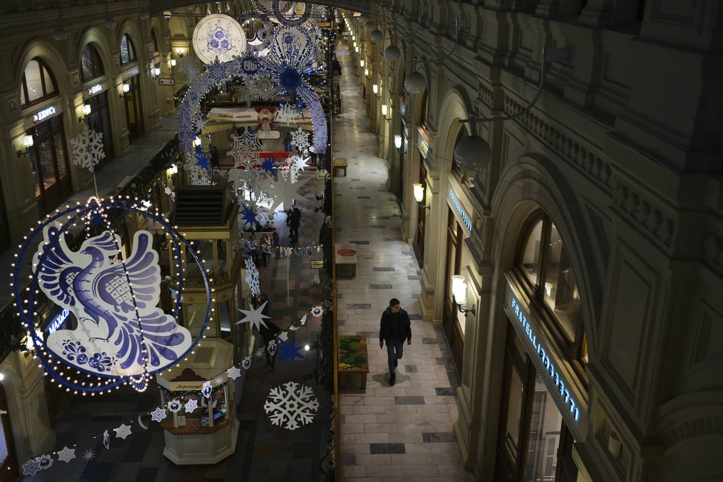 En kunde går forbi stengte butikker i kjøpesenteret GUM i Moskva i januar i år. Hundrevis av vestlige selskaper har trukket seg ut av Russland etter krigen. Foto: AP / NTB. 