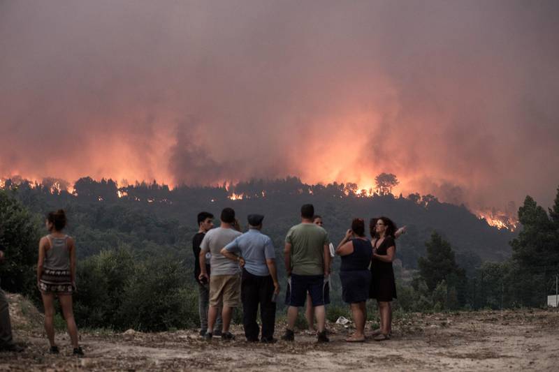 Bildet viser folk som ser på skogbrannene i rundt Monchique i regionen Algarve i Portugal.