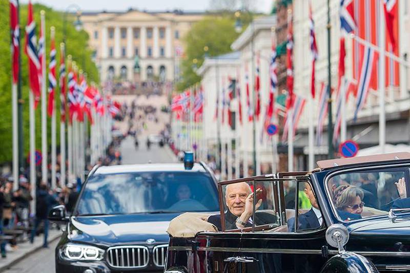 Oslo 20200517. 
Kong Harald og dronning Sonja kommer kjører nedover Karl Johans gate i åpen bil under 17. mai feiringen i Oslo. Nasjonaldagen feires i år på en ny og annerledes måte på grunn av koronoaviruset.
Foto: Fredrik Varfjell / NTB scanpix