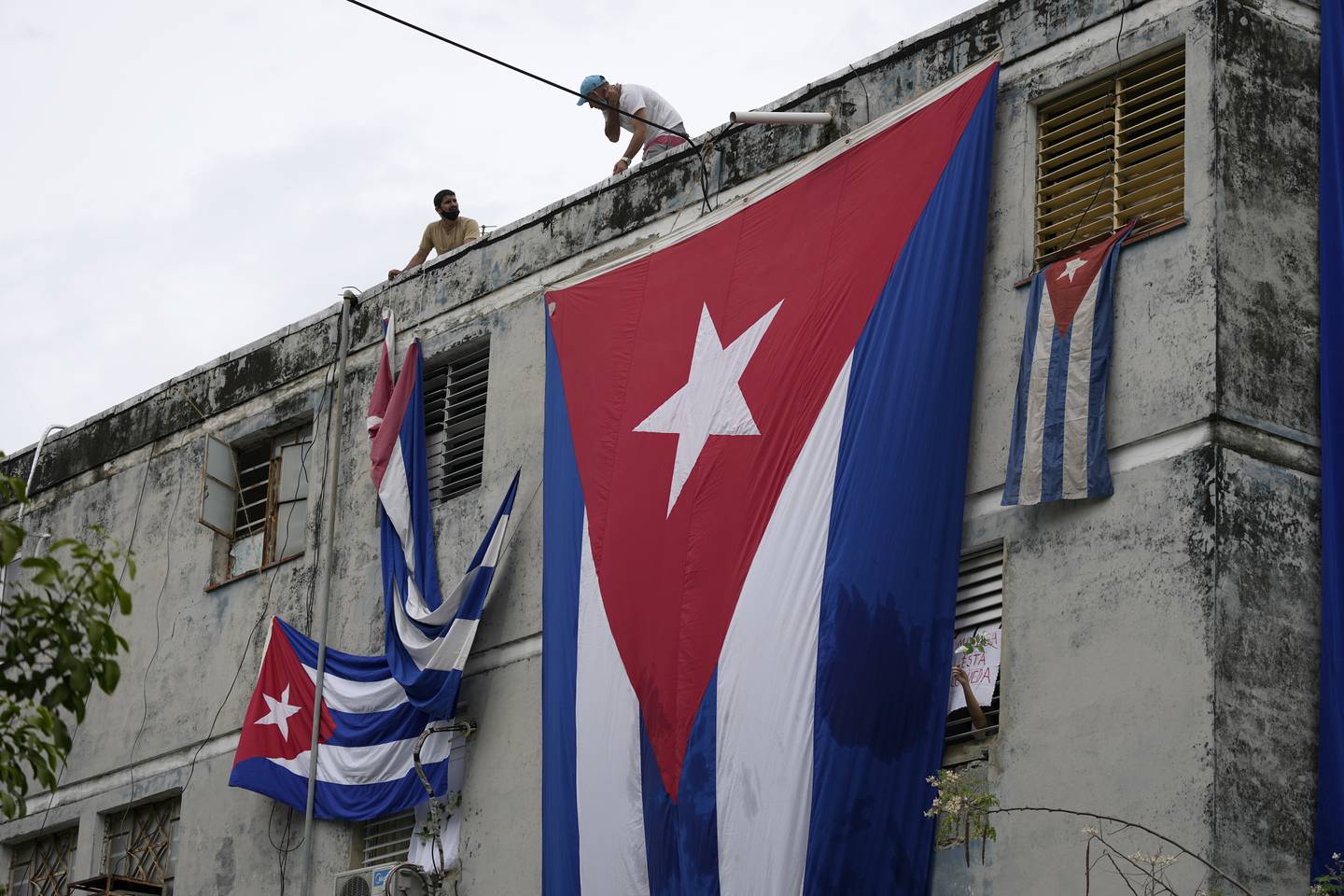 Cubanske flagg henger flagg foran vinduene der aktivisme Yunior Garcia Aguilera bor i et forsøk på å hindre ham fra å kommunisere med omverdenen. Foto: Ramon Epinosa / AP / NTB