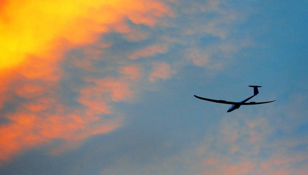 A glider plane cruises through the sky coloured by the sunset above Sion in the Canton of Valais, Switzerland, Thursday evening, May 20, 2004. Temperatures reached up to 30 degrees in that part of Switzerland providing good thermic conditions for glider planes to fly. ((AP Photo/Keystone, Olivier Maire)