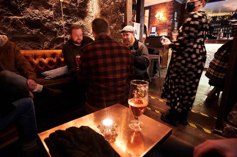 Bildet viser folk som sitter på en bar i Reykjavik.