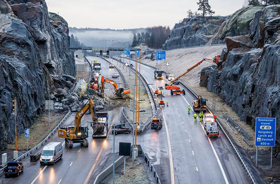 Bildet viser veien E18 ved Larvik. En stor stein ligger på veien. Vegvesenet skal sprenge den fredag. Steinen ligger igjen på veien etter et ras fredag. 