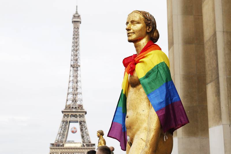 Bildet viser en statue kledd med regnbueflagget i Paris i Frankrike.