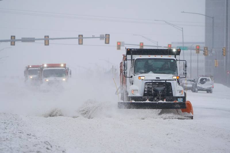 Bildet er av en bil med snøplog. Den brøyter vekk snø i Oklahoma City. To andre brøytebiler følger i snøføyka bak den første.