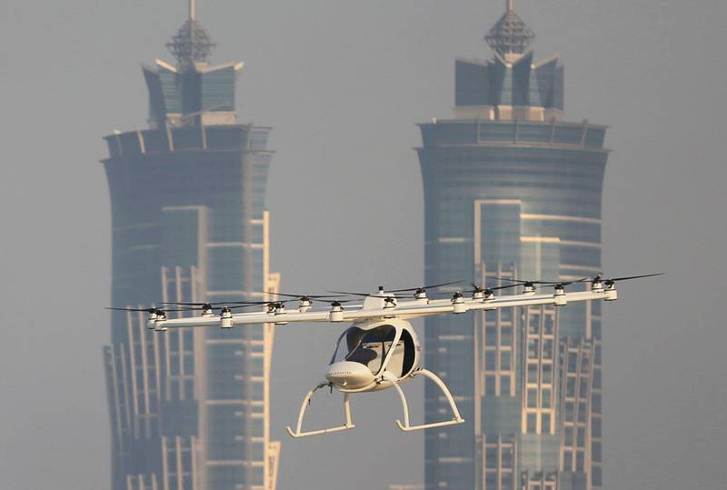 Bildet viser et volocopter som flyr foran bygninger i Dubai.