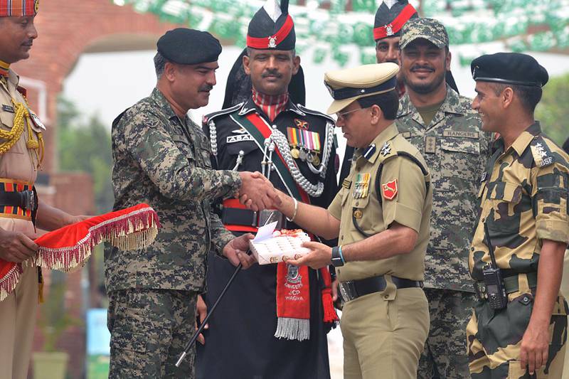 Bildet vise at militære smiler, tar hverandre i hånden og gir hverandre gaver. De vokter grensa mellom Pakistan og India.