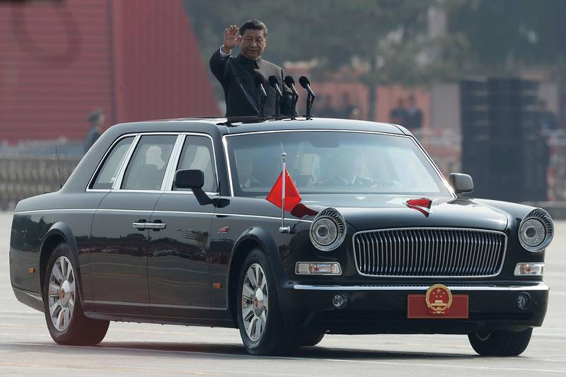 Bildet viser Den kinesiske presidenten Xi Jinping vinker fra en bil med åpent tak. 