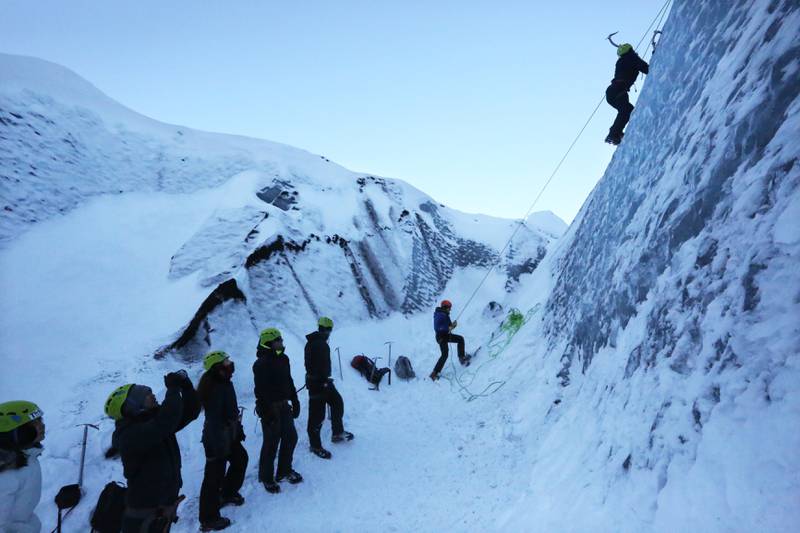 Bildet viser folk som klatrer på isbreen Sólheimajökull på Island.