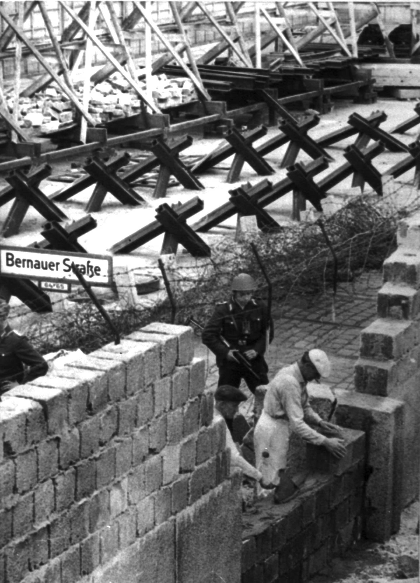 Bildet er av bygging av en mur foran andre sperringer. Det er en del av Berlinmuren som er bygd våren 1962.