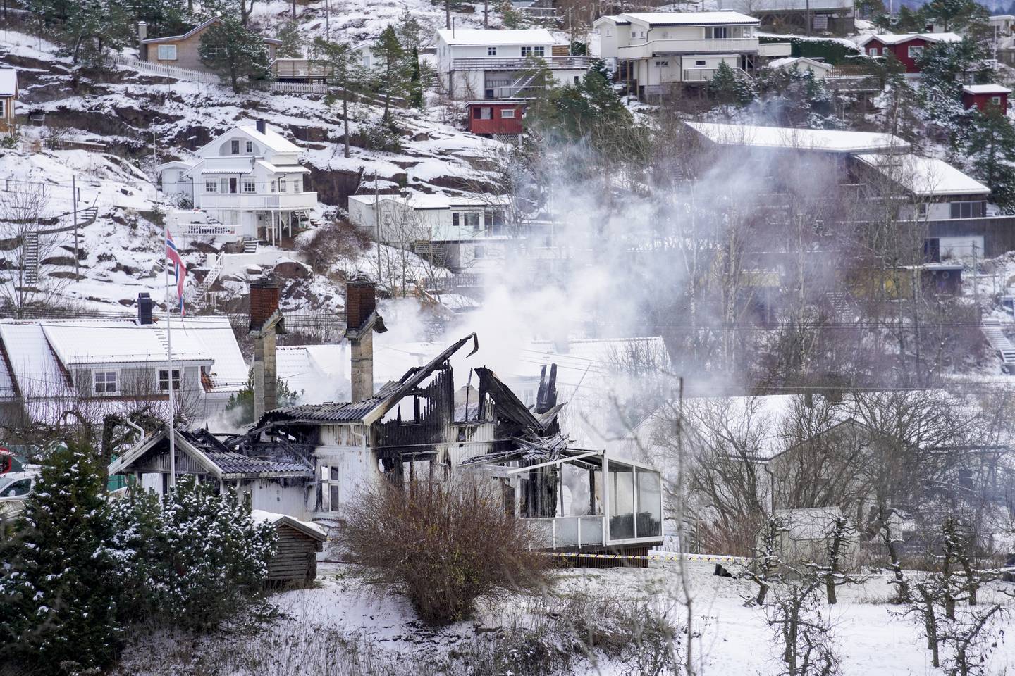 En enebolig i Svelvik brant ned natt til mandag. To voksne og to barn er savnet etter brannen. Foto: Terje Bendiksby / NTB