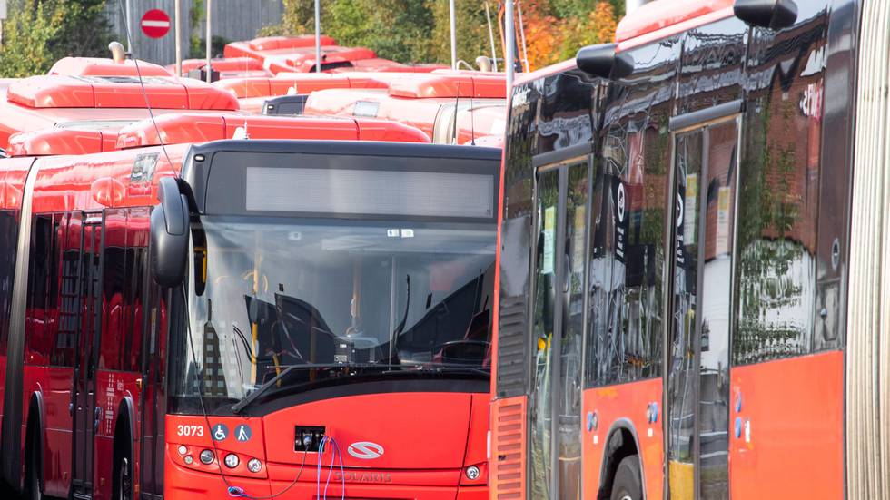 Bildet viser røde Ruter-busser som står stille.