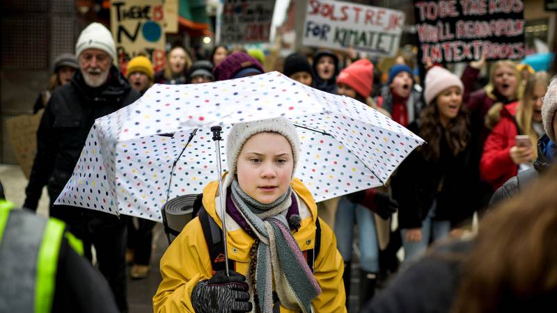 Bildet viser aktivisten Greta Thunberg med en paraply.