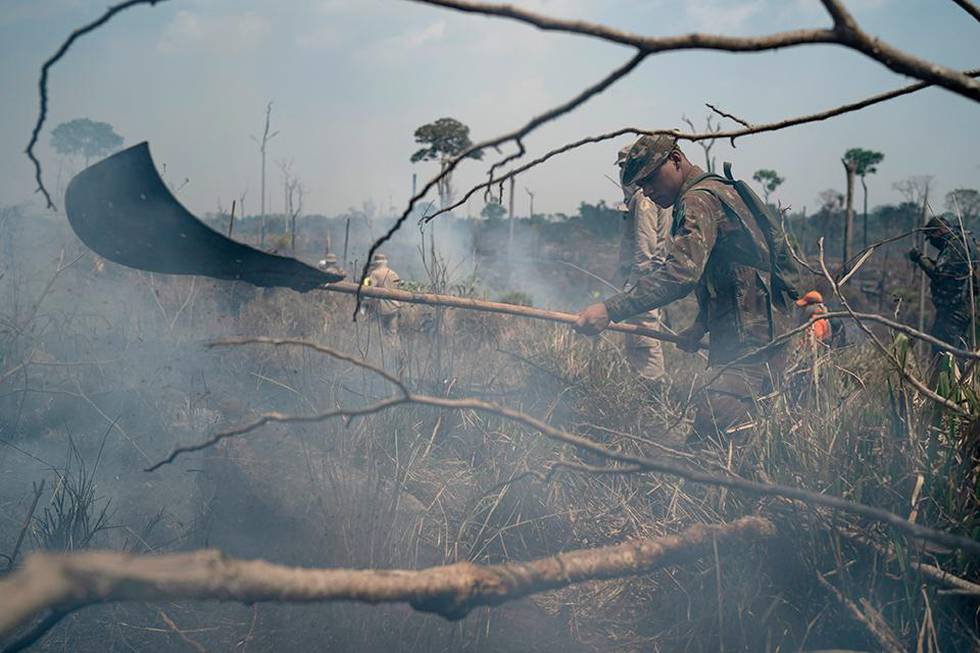 Bildet viser en brasiliansk soldat som jobber med å slukke en brann i Brasil. Det er mer forurensing i lufta i landet.