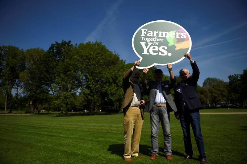 Biletet viser tre irske bønder. Dei held ei plakat der det står at dei er for å fjerne forbodet mot abort.